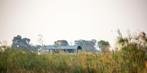 a building with a blue roof in a field at The Namushasha River Villa in Kongola