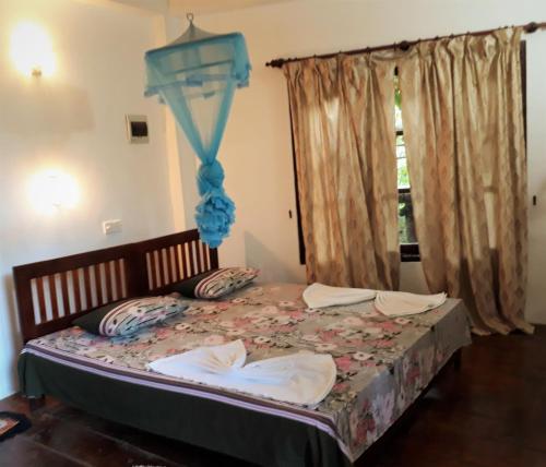 a bedroom with a bed with a blue canopy at Seasons Four Mini Jungle Cabana in Matara