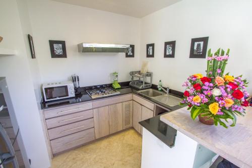 a kitchen with a vase of flowers on a counter at Vishuddha Ajna Villa - Outstanding 2 bdr villa - GREAT LOCATION! in Seminyak