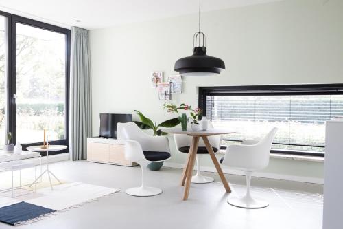 a white living room with a table and chairs at B&B StudioLKE in Heeze
