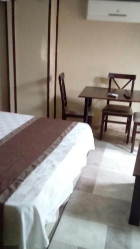 a bedroom with a bed and a table and a chair at Lena Central Flats in Bursa