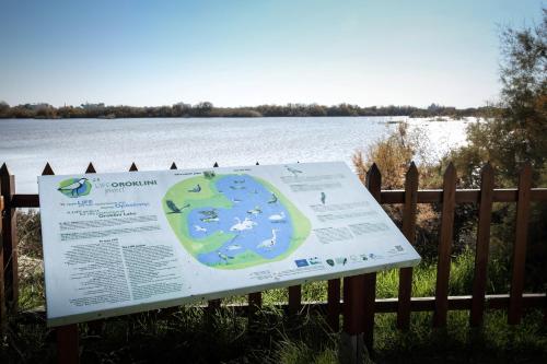 a sign on a fence next to a lake at Lithos Studios in Voroklini