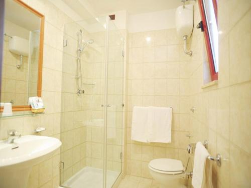 y baño con ducha, aseo y lavamanos. en Hotel Poseidonia Mare, en Paestum