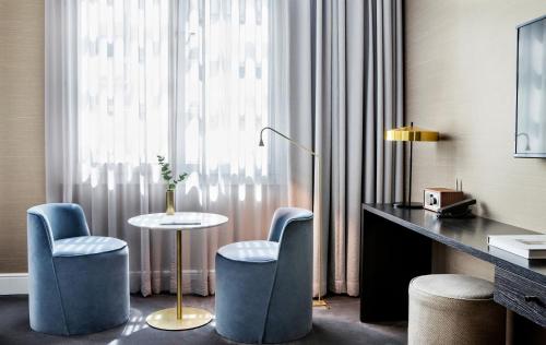 a hotel room with a desk and two chairs and a table at Pillows Grand Boutique Hotel Reylof Ghent in Ghent
