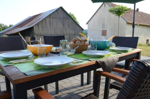 une table en bois avec des assiettes et des bols dans l'établissement erholBAR, à Eckfeld