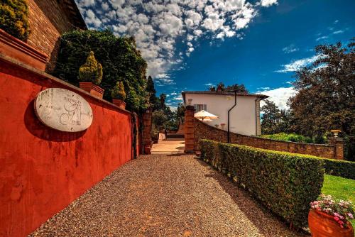 a red wall with a sign on the side of it at Borgo Grondaie in Siena
