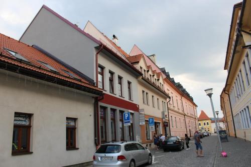 a street with buildings and a car parked on the street at Centrum Apartman LEYLA in Bardejov