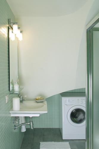 a bathroom with a sink and a washing machine at ClassBedroom Barcelona Beach Apartments in Barcelona