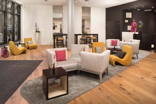 a living room with colorful chairs and a couch at INNSiDE by Meliá Frankfurt Ostend in Frankfurt/Main