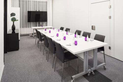 a conference room with a long table and chairs at INNSiDE by Meliá Frankfurt Ostend in Frankfurt/Main