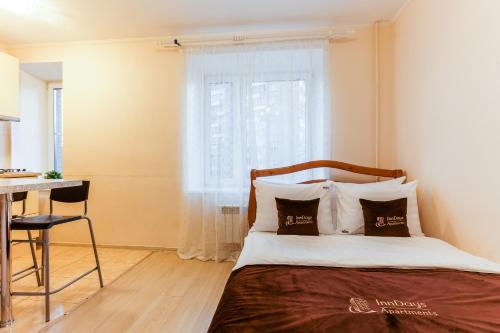 モスクワにあるInnDays on Avtozavodskayaのベッドルーム1室(ベッド1台、テーブル、窓付)
