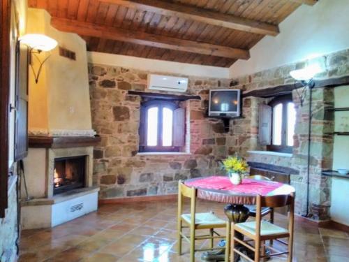 a living room with a table and a fireplace at Villaggio dei Balocchi in Castelbuono