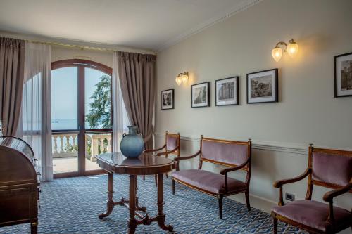 a room with chairs and a table and a window at Hotel Villa Del Sogno in Gardone Riviera