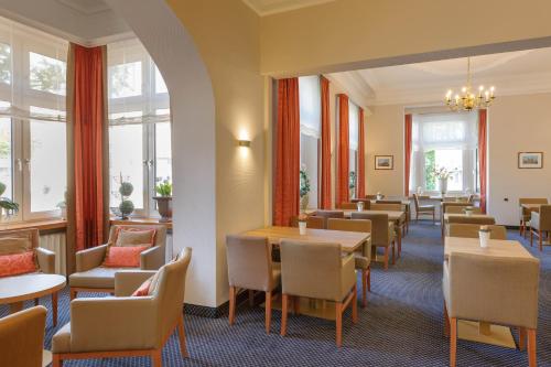 a restaurant with tables and chairs and windows at Mercure Hotel Luebeck City Center in Lübeck