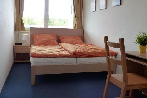クックスハーフェンにあるFrische Brise 01.03のデスク、窓が備わるドミトリールームのベッド1台分です。
