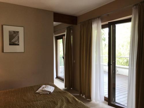 um quarto com uma cama e uma grande janela em APARTAMENT 304 Willa Port em Ostróda
