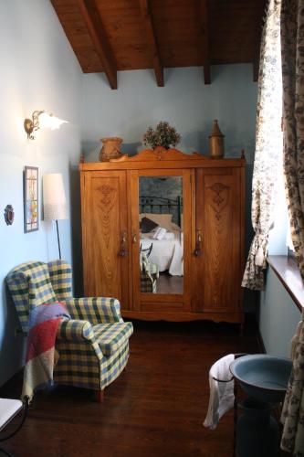 a living room with a cabinet and a bed at Casa Rural La Xiarapina in Serrapio