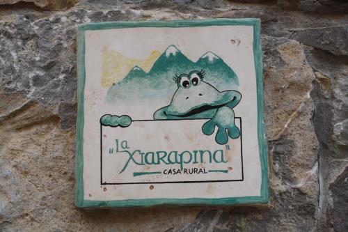 a sign with a frog hanging on a wall at Casa Rural La Xiarapina in Serrapio