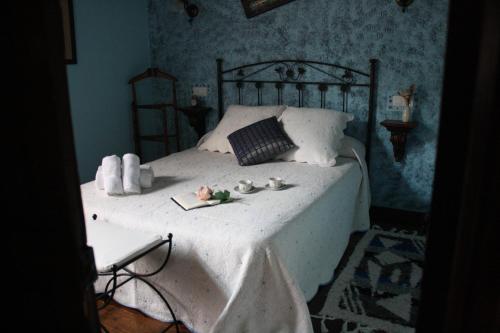 una camera da letto con un letto con lenzuola bianche e fiori di Casa Rural La Xiarapina a Serrapio