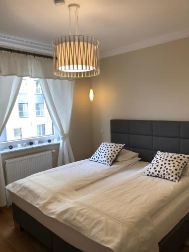 a bedroom with a large bed and a chandelier at Aqua Apartments in Reda