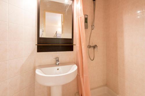 La salle de bains est pourvue d'un lavabo et d'une douche avec un miroir. dans l'établissement Premiere Classe Annecy Nord - Epagny, à Épagny