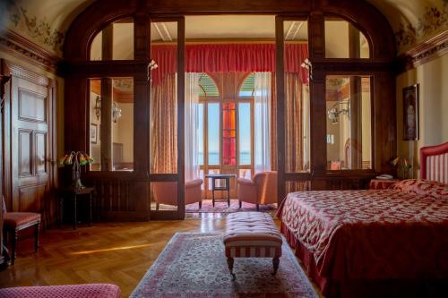 a bedroom with a bed and a large window at Hotel Villa Del Sogno in Gardone Riviera