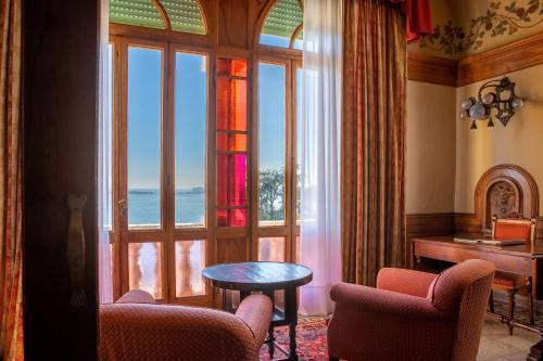 a room with a large window with a table and chairs at Hotel Villa Del Sogno in Gardone Riviera