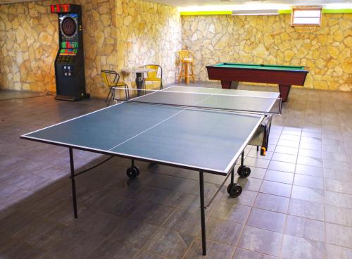 a ping pong table in a room with two tables at Szent Orbán Erdei Wellness Hotel és Residence in Kóspallag