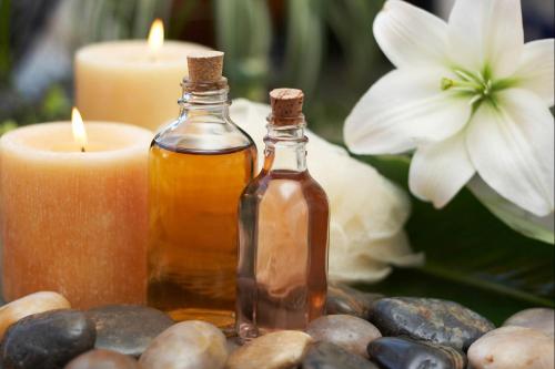 two bottles of essential oils and candles on a table at Samsara Inn in Legian