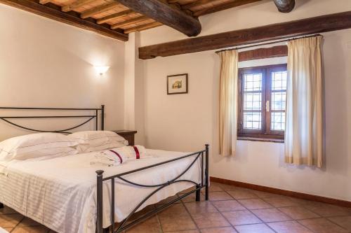 a bedroom with a bed and a window at Borgo Il Poggiaccio Residenza d'Epoca in Sovicille