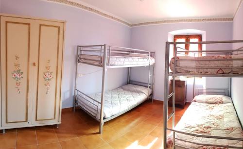 Zimmer mit 2 Etagenbetten und einer Tür in der Unterkunft Casa Vecia in Bracca