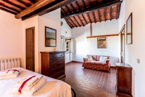 a bedroom with a bed and a chair in a room at Borgo Il Poggiaccio Residenza d'Epoca in Sovicille