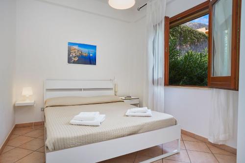 a bedroom with a bed with two towels on it at Case di Calamazzo in Scopello