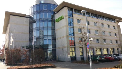 un edificio con una señal verde en el costado. en Wyndham Garden Hennigsdorf Berlin en Hennigsdorf