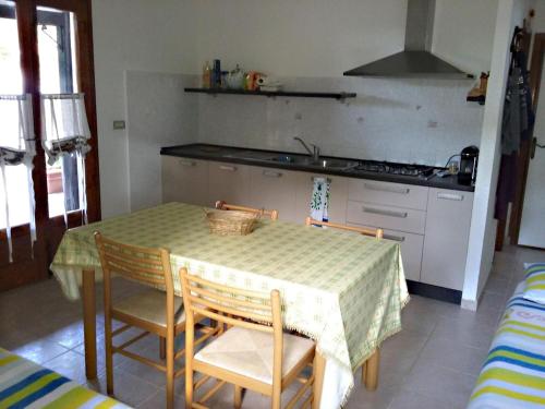 a kitchen with a table and chairs and a kitchen with a sink at MERAVIGLIOSO VILLINO DIRETTAMENTE SUL MARE con posto auto e aria condizionata! in Capoliveri
