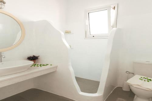a white bathroom with a sink and a mirror at Andriani's Guest House in Mýkonos City