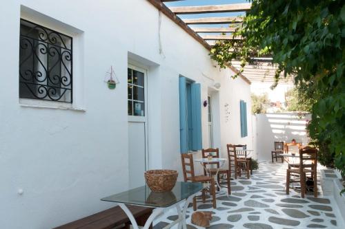 a patio with a glass table and chairs on a building at Andriani's Guest House in Mýkonos City