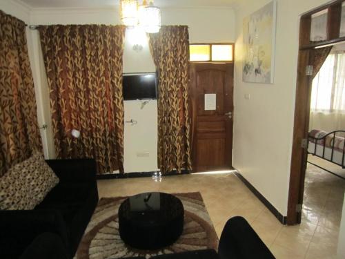 a living room with a couch and a table and a door at Jakicha Motel in Dar es Salaam