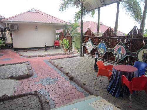 a patio with a table and chairs and a fence at Jakicha Motel in Dar es Salaam