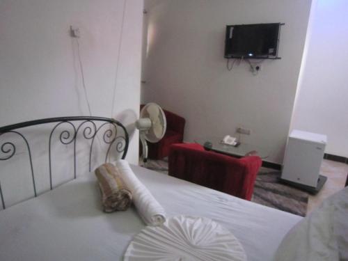 a bedroom with a bed and a tv in a room at Jakicha Motel in Dar es Salaam