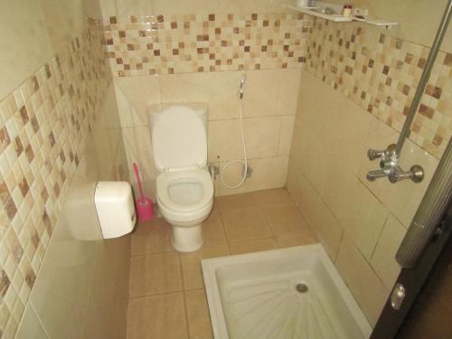 a small bathroom with a toilet and a tub at Jakicha Motel in Dar es Salaam