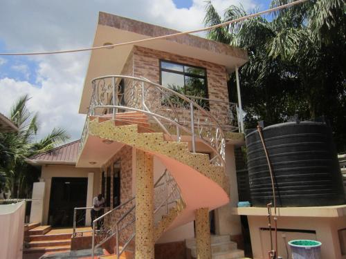 a house with a spiral staircase in front of it at Jakicha Motel in Dar es Salaam