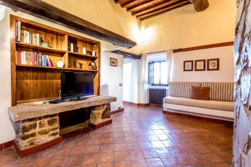 a living room with a tv and a fireplace at Borgo Il Poggiaccio Residenza d'Epoca in Sovicille