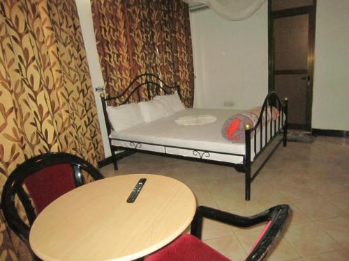 a room with a bed and a table and chairs at Jakicha Motel in Dar es Salaam