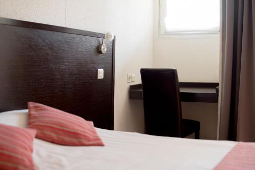 a bed with a black door and a red pillow at Top Motel in Istres