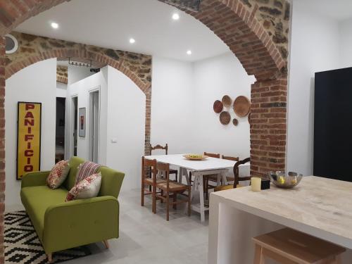 a living room with a green couch and a table at Casa Antico Forno in Manciano