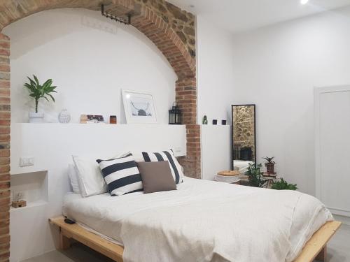 1 dormitorio con 1 cama con pared de ladrillo en Casa Antico Forno, en Manciano