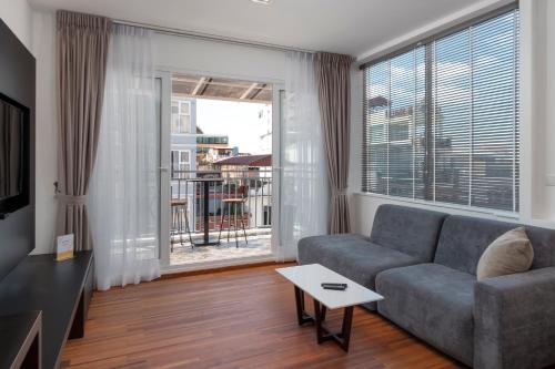a living room with a couch and a large window at TAO Riverside Residence in Phnom Penh