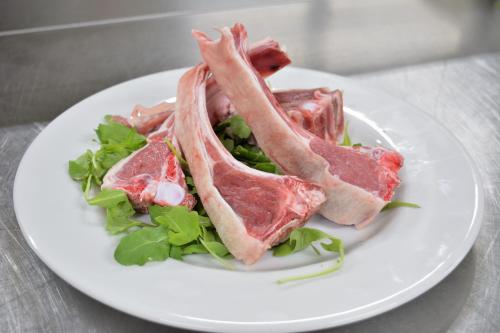 a white plate with three pieces of meat on a salad at Borgo Saraceno in Spinazzola
