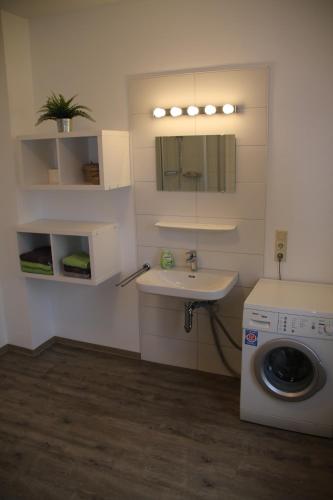 a bathroom with a washing machine and a sink at Wind & Wasser in Emden